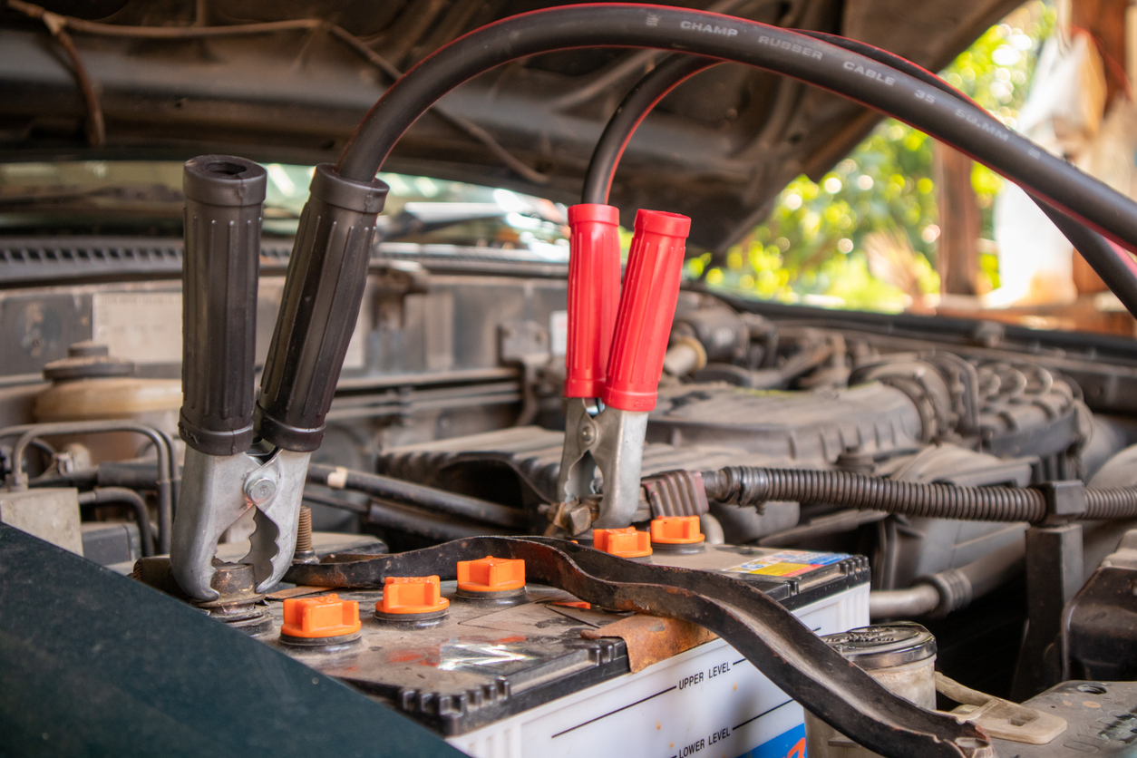 Dead car battery with jumper cables attached