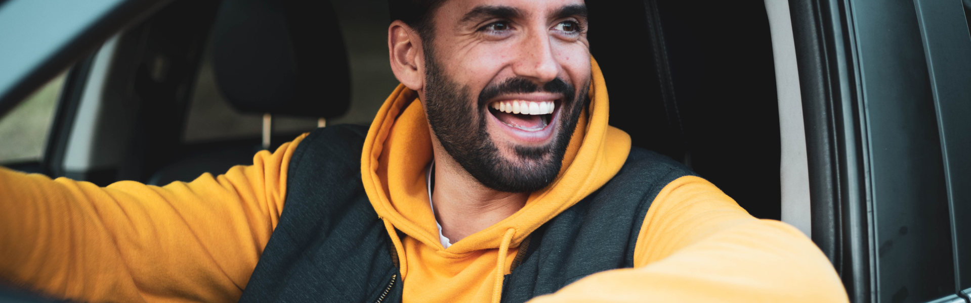 Man Happily driving off with his purchased used vehicle